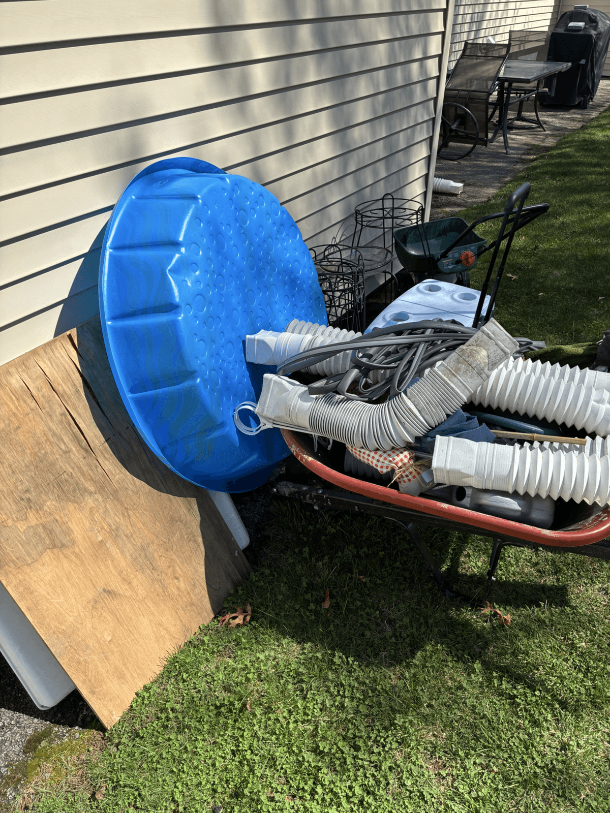 Outdoor items gathered along a house before junk removal